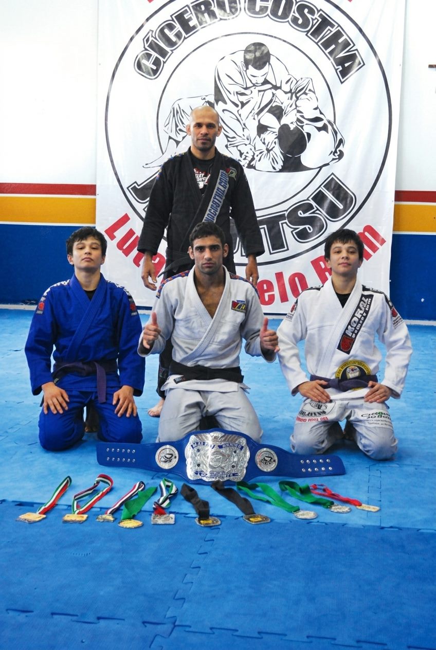 Mestre Cícero Costha com Leandro Lo e os irmãos Miyao ainda adolescentes, ao lado das medalhas e do cinturão conquistados